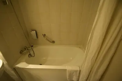 a bathroom with a bath tub with a shower curtain at DC Sleep & Go Brussels West in Brussels