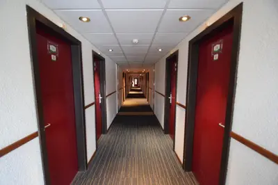 a corridor of a hallway with red doors at DC Sleep & Go Brussels West in Brussels