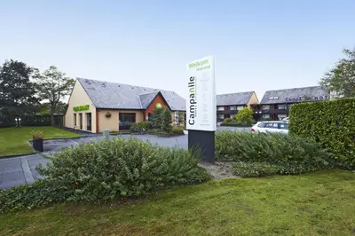 a sign in the grass in front of a house at Campanile Hotel & Restaurant Gent in Ghent