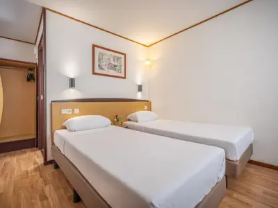 a room with two beds in a hospital room at Campanile Hotel & Restaurant Gent in Ghent
