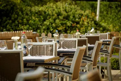 a group of tables and chairs with wine bottles on them at Campanile Hotel & Restaurant Gent in Ghent