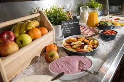 a buffet with apples and other food on a table at Campanile Hotel & Restaurant Gent in Ghent