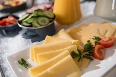 a plate of cheese and vegetables on a table at Campanile Hotel & Restaurant Gent in Ghent