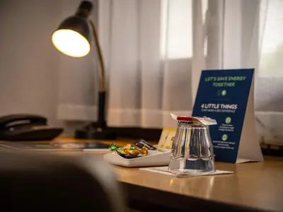 a desk with a coffee maker and a book on it at Campanile Hotel & Restaurant Gent in Ghent