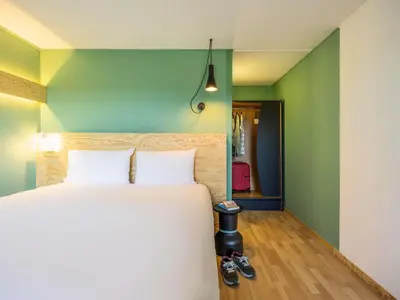 a bedroom with a white bed and a green wall at greet Brussels Airport Zaventem in Zaventem