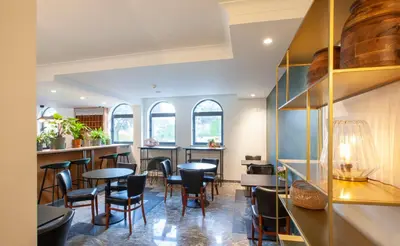 a restaurant with tables and chairs and windows at Hotel The Shepherd in Leuven