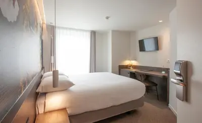 a hotel room with a bed and a desk at Hotel The Shepherd in Leuven