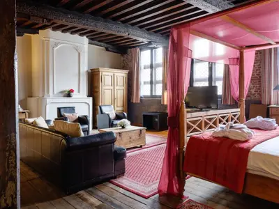 a bedroom with a canopy bed and a living room at Ghent River Hotel in Ghent