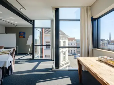 a room with a large window and a table at Ghent River Hotel in Ghent