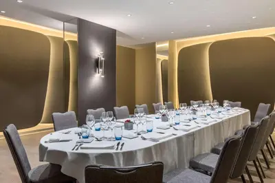 a conference room with a long table and chairs at NH Collection Brussels Grand Sablon in Brussels