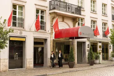 two people walking in front of a building at NH Collection Brussels Grand Sablon in Brussels