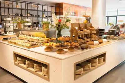 a bakery with a buffet of food on a counter at Van der Valk Hotel Antwerpen in Antwerp