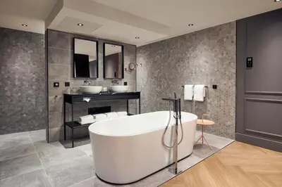a bathroom with two sinks and a bath tub at Van der Valk Hotel Antwerpen in Antwerp