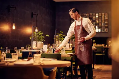 a man standing in a restaurant preparing food at Van der Valk Hotel Antwerpen in Antwerp