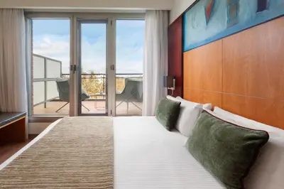 a bedroom with a large bed and a balcony at Catalonia Brussels in Brussels