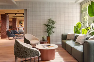 a lobby with a couch and chairs and a table at Catalonia Brussels in Brussels