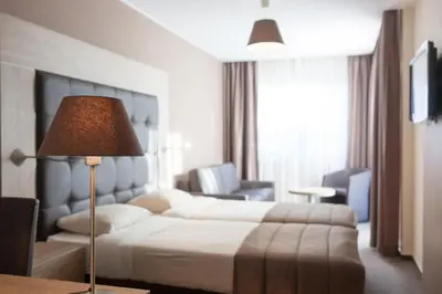 a hotel room with a bed and a lamp at Hotel Villa Royale in Brussels