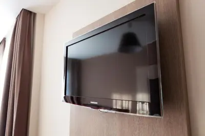 a flat screen television hanging on a wall at Hotel Villa Royale in Brussels