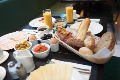 a table topped with a tray of bread and other foods at Hotel Villa Royale in Brussels