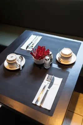 a table with plates and silverware on top of it at Hotel Villa Royale in Brussels