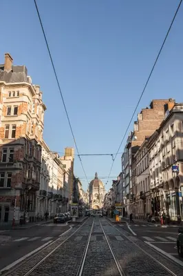 an empty street with train tracks in a city at Hotel Villa Royale in Brussels