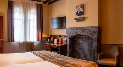 a hotel room with a fireplace and a bed at Hotel Monasterium PoortAckere Ghent in Ghent