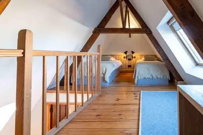 a attic bedroom with two beds and a staircase at Hotel Monasterium PoortAckere Ghent in Ghent