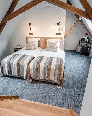 a bedroom with a large bed in a attic at Hotel Monasterium PoortAckere Ghent in Ghent