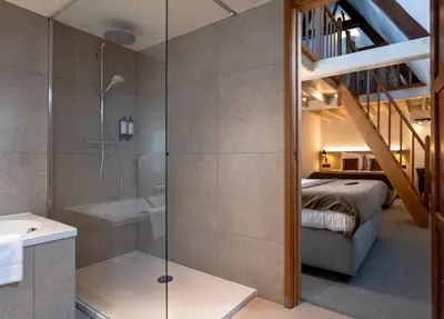 a bathroom with a shower and a bedroom with a bed at Hotel Monasterium PoortAckere Ghent in Ghent