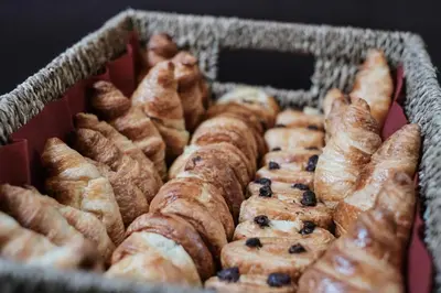 a basket full of blueberry muffins and other pastries at Hotel Brouwerij Het Anker in Mechelen