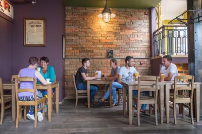 a group of people sitting at tables in a restaurant at Hotel Brouwerij Het Anker in Mechelen