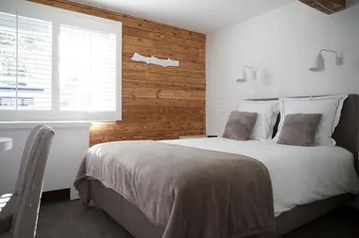 a bedroom with a large bed with a wooden wall at Hotel Made In Louise in Brussels