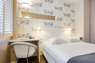 a bedroom with a bed and a desk and a chair at Hotel Made In Louise in Brussels