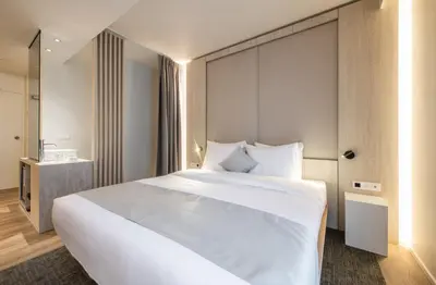 a bedroom with a large white bed in a room at Begijnhof Hotel in Leuven