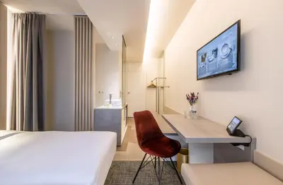 a hotel room with a bed and a desk at Begijnhof Hotel in Leuven