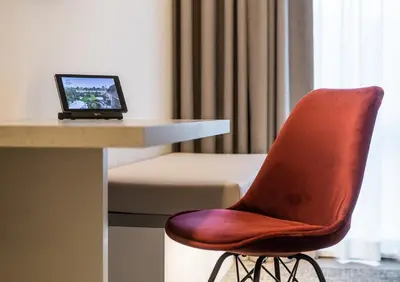 a red chair sitting next to a desk with a laptop at Begijnhof Hotel in Leuven