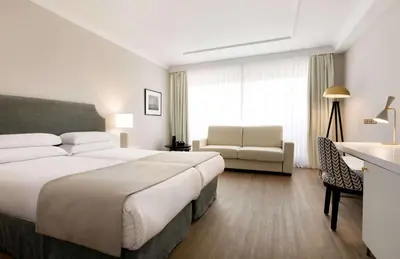 a hotel room with a large bed and a chair at Hotel Avenue Louise Brussels Trademark Collection by Wyndham in Brussels