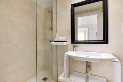 a bathroom with a sink and a mirror at Hotel Avenue Louise Brussels Trademark Collection by Wyndham in Brussels