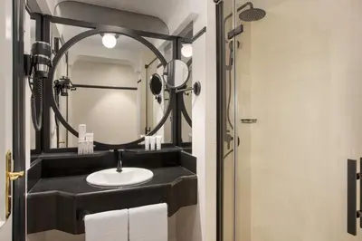 a bathroom with a sink and a mirror at Hotel Avenue Louise Brussels Trademark Collection by Wyndham in Brussels