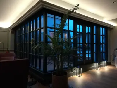 a large glass room with a potted plant in it at Hotel Avenue Louise Brussels Trademark Collection by Wyndham in Brussels