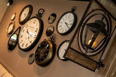 a bunch of clocks hanging on a wall at Charmehotel Klokkenhof in Brasschaat