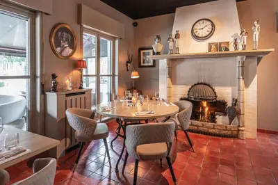a dining room with a table and a fireplace at Charmehotel Klokkenhof in Brasschaat