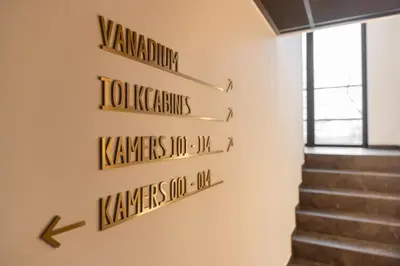 a group of signs on a wall with stairs at Bremberg Hotel in Haasrode