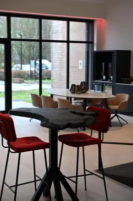 a table and chairs in a room with windows at Bremberg Hotel in Haasrode