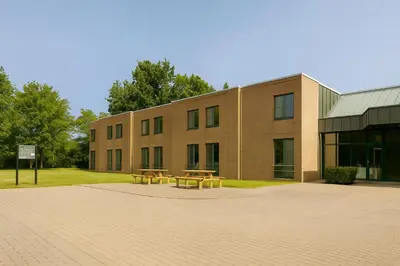 a building with two picnic tables in front of it at Bremberg Hotel in Haasrode