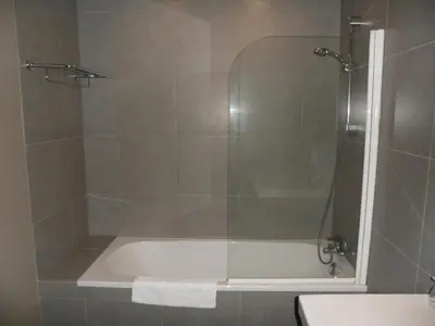 a bathroom with a shower with a bath tub at Hotel De Franse Kroon in Diest