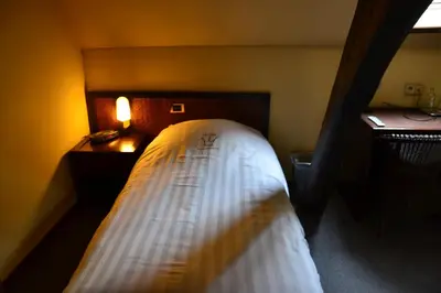 a bedroom with a bed and a desk with a lamp at Hotel De Franse Kroon in Diest