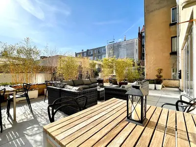 a wooden deck with furniture on top of a building at Hotel De Fierlant in Brussels