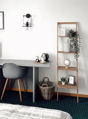 a desk in a room with a chair and a shelf at Hotel De Fierlant in Brussels