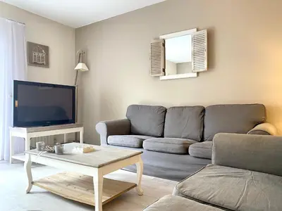 a living room with a couch and a tv at Hotel De Fierlant in Brussels